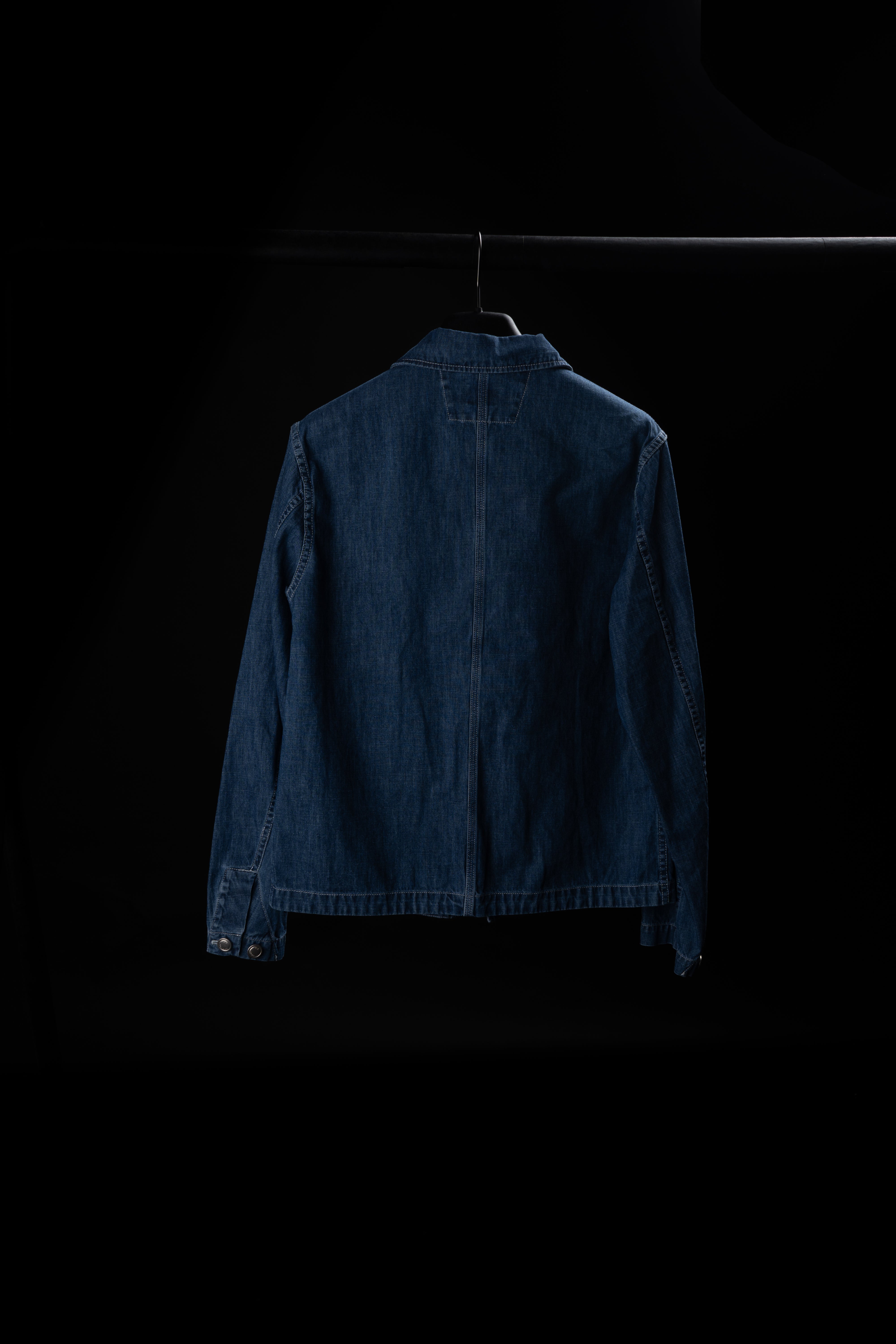 Veste CP Company en jean bleu suspendue, offrant un style décontracté et durable pour une tenue moderne.