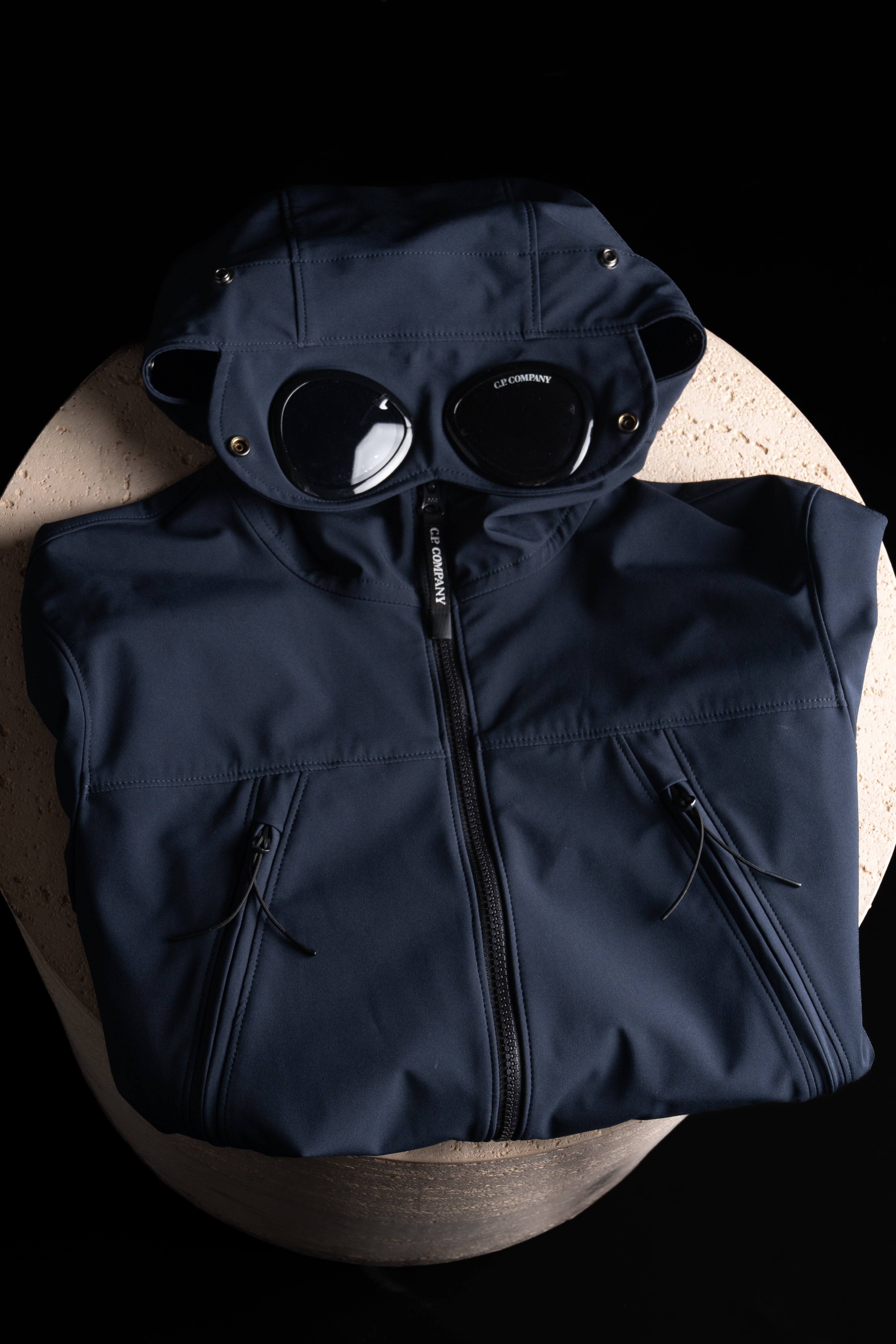 Veste Cp Company Bleu Marine Posé sur un support en pierre