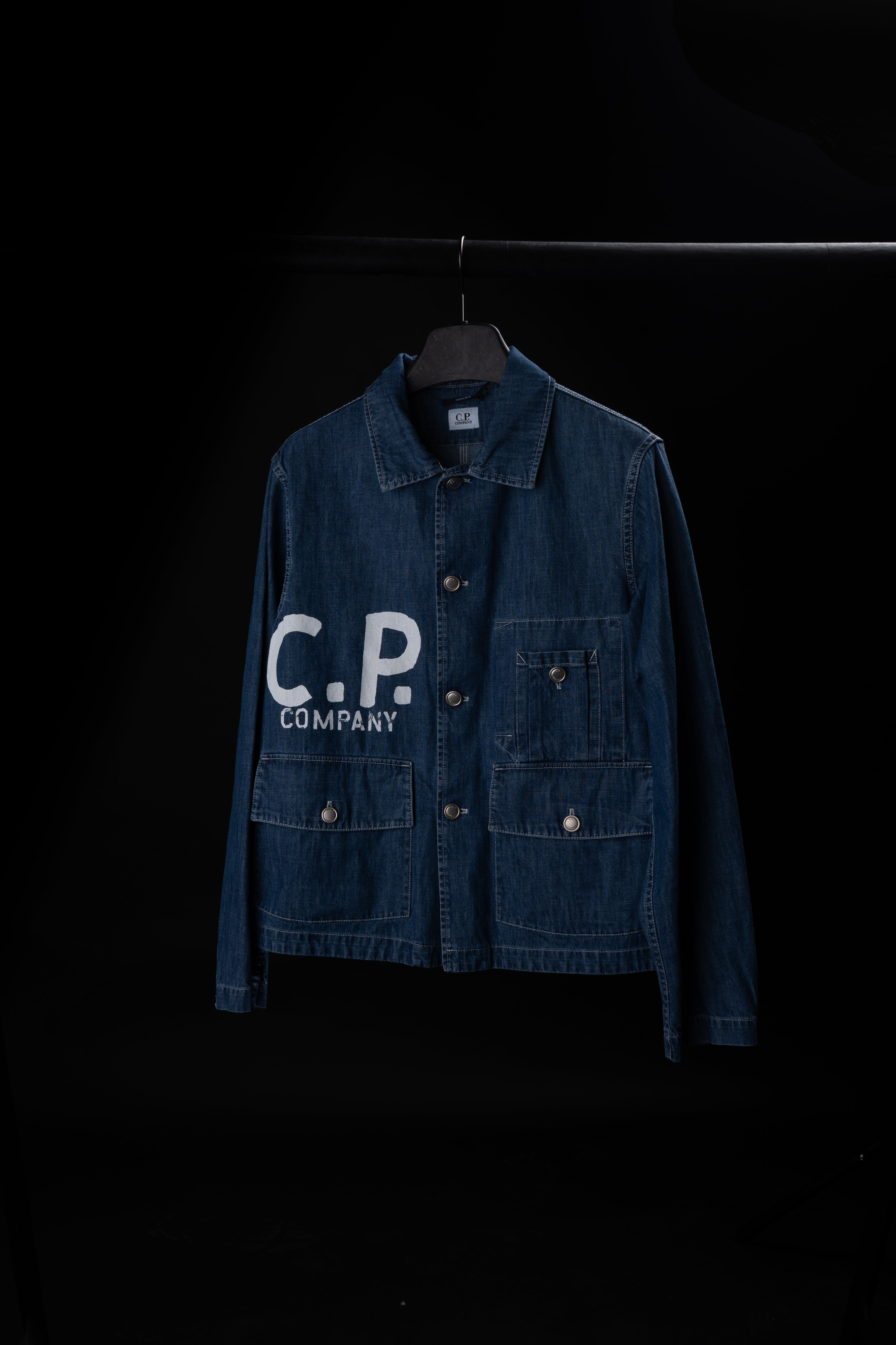 Veste CP Company en jean bleu avec logo brodé sur la poitrine, idéale pour un look décontracté et tendance.
